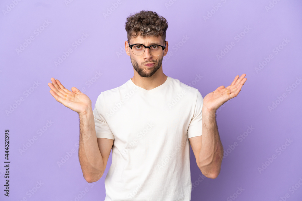 Delivery caucasian man isolated on purple background having doubts while raising hands Delivery caucasian man isolated on purple background having doubts while raising hands