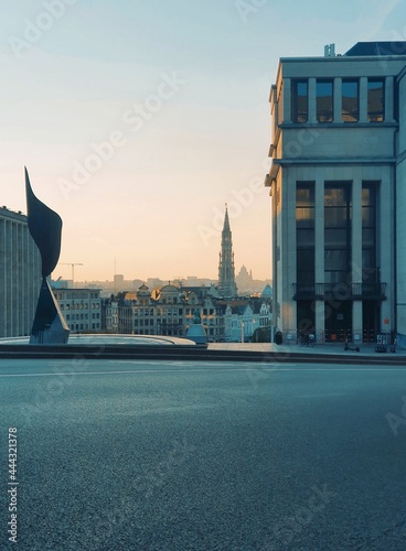 Early evening sunset view of the Mont des Arts in Brussels, Belgium. A blue tint covers the view with a creamy orange sky in the background. Several famous buildings can be seen as well.
