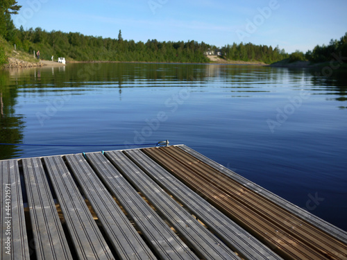 Wooden dock in ivalo clear river at midnight time finland scandinavia