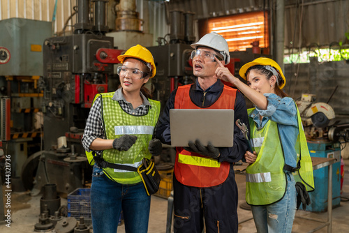 Industrial engineers have consult with femal colleagues while using laptop. Supervisor and worker working in manufacturing factory on business day. Workplace gender equality concepts.