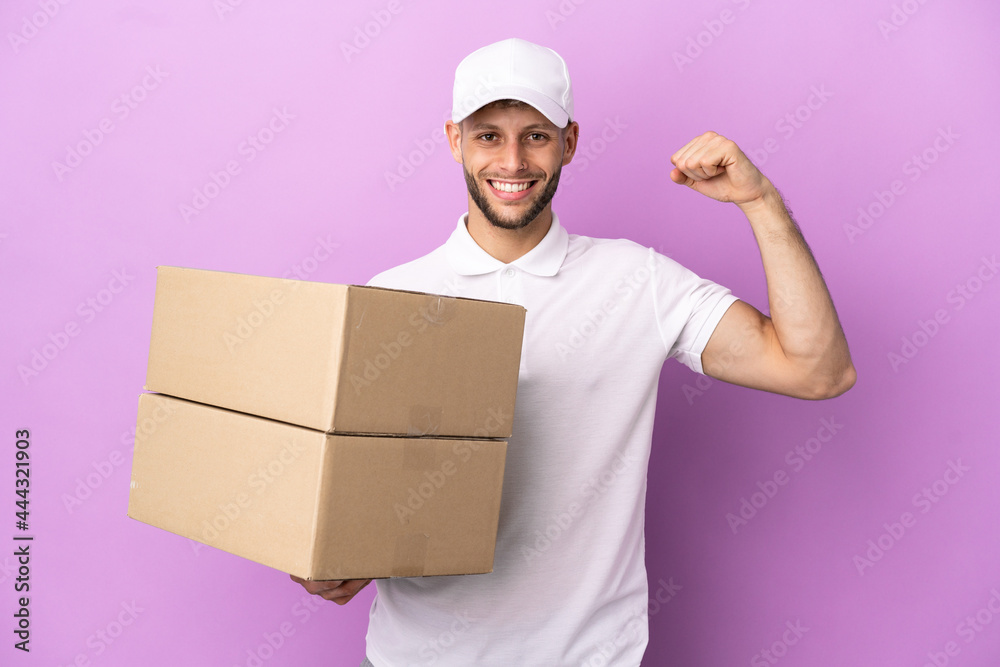 Delivery caucasian man isolated on purple background doing strong gesture Delivery caucasian man isolated on purple background doing strong gesture