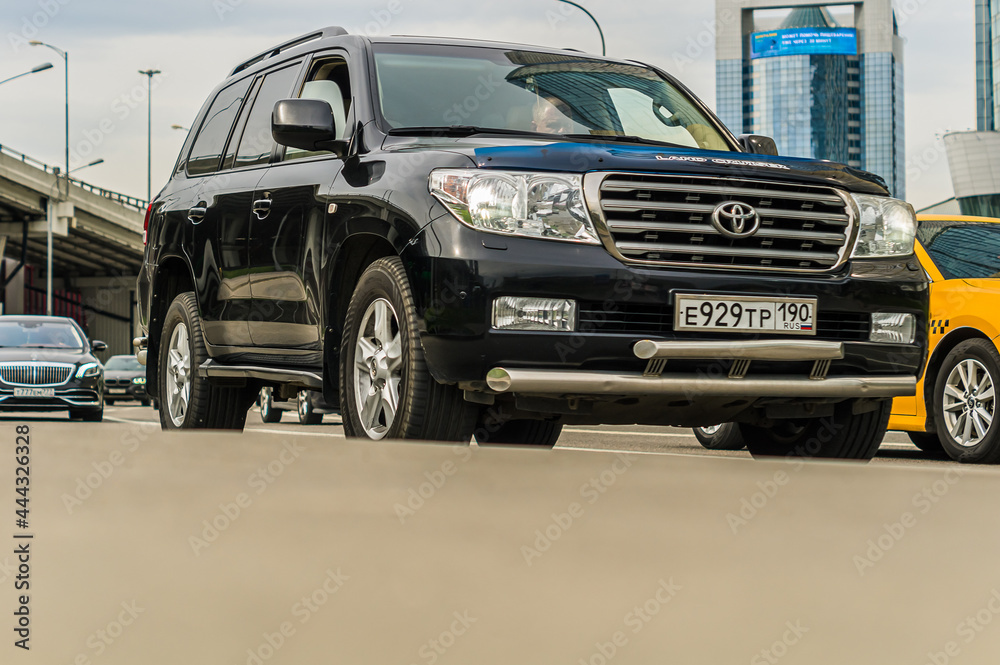 Toyota Land Cruiser 200 is driving in the cityscape. Front side view of