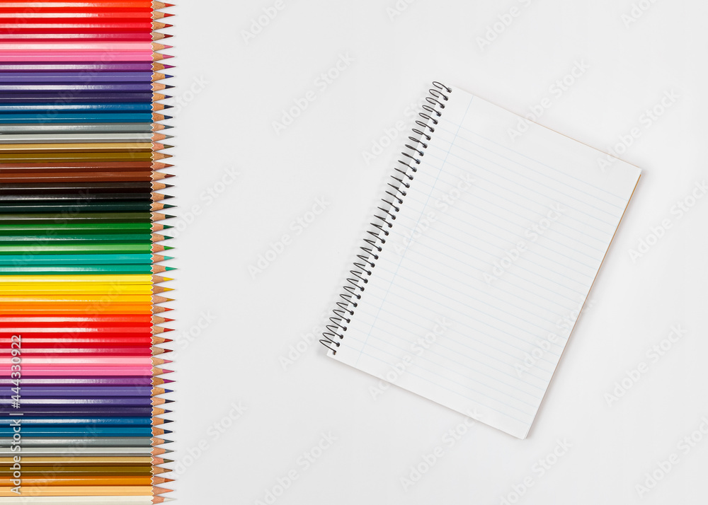 Row of color pencils and a striped notebook for Row of color pencils and a striped notebook for