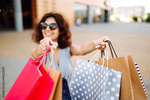 Shopping bags in the woman hands. Young woman after shopping. Sale, shopping, tourism and happy people concept.