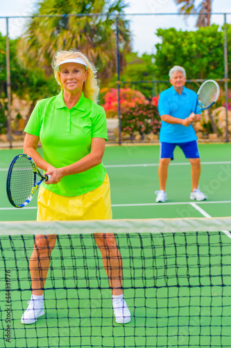 Senior couple playing tennis on sunny day.
