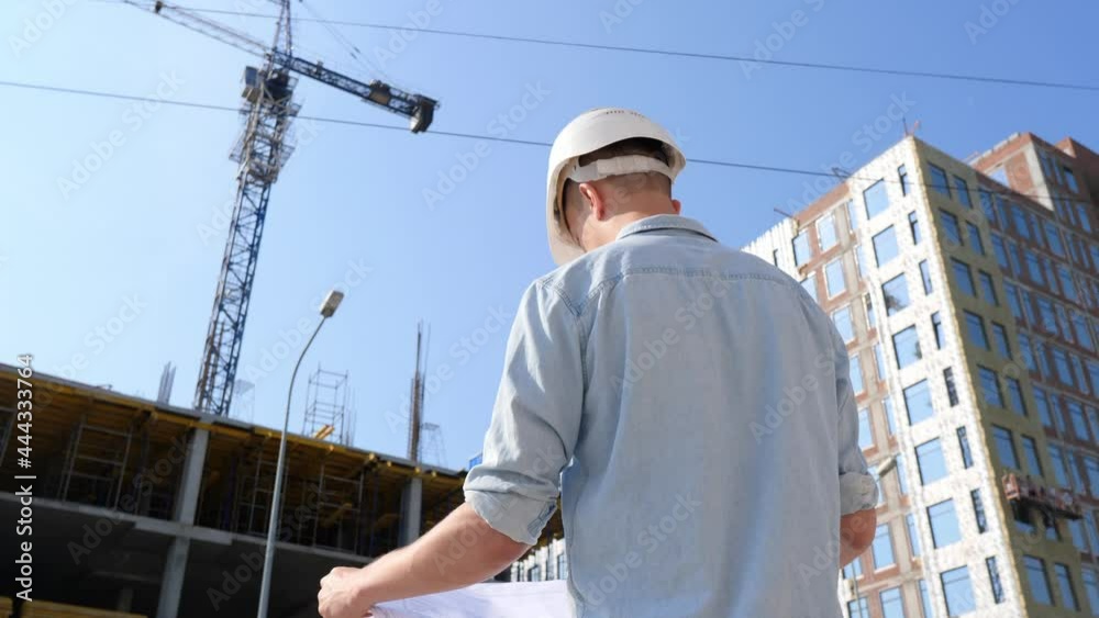 Construction specialist engineer uses a blueprint at a construction site. Real estate construction project with a civil engineer. Construction specialist engineer uses a blueprint at a construction site. Real estate construction project with a civil engineer.