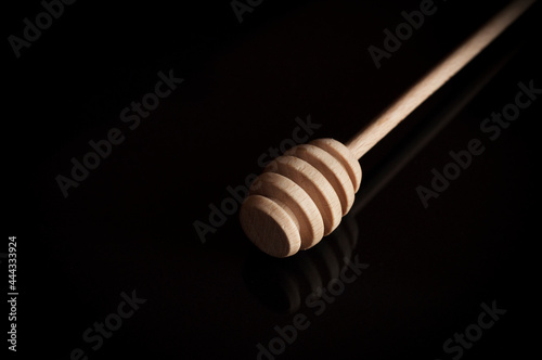 pure wooden honey spoon on a black background. High quality photo