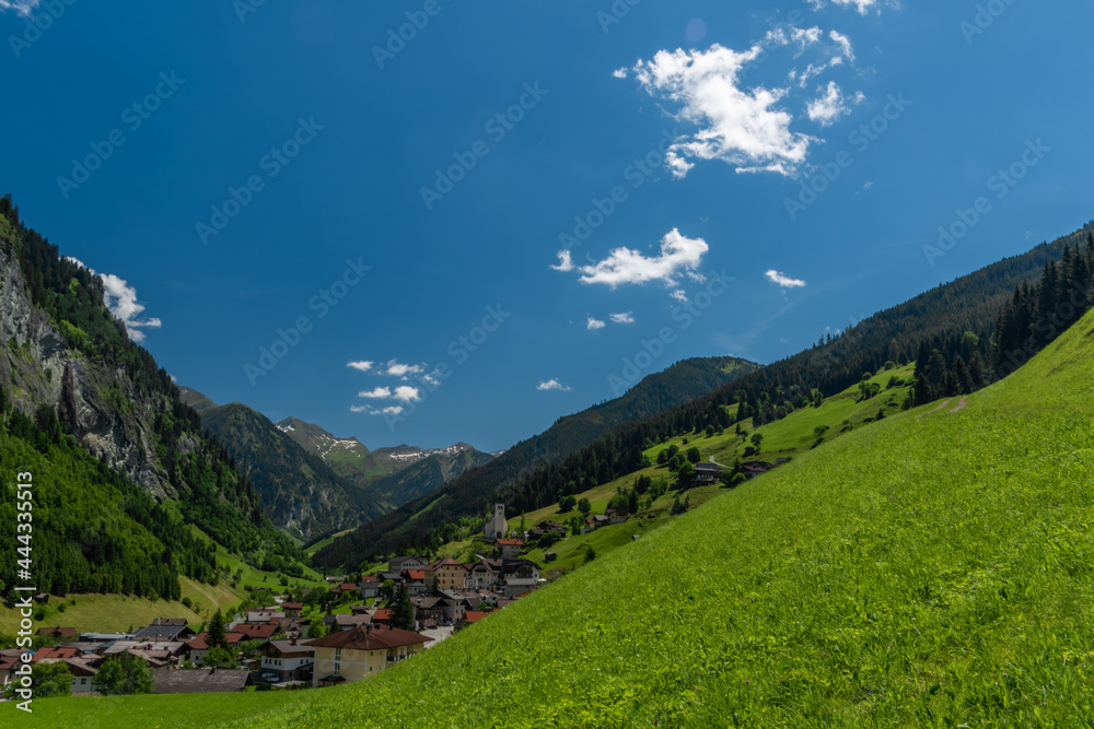 Summer valley with Grossarler Ache small river and blue cloudy sky