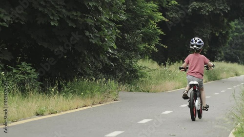 Wallpaper Mural Child riding bicycle on the bike path at rain. Kid in helmet learning to ride at summer Torontodigital.ca