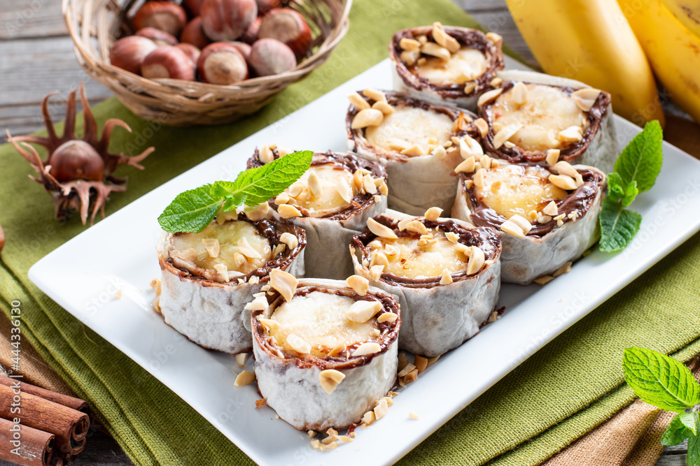 Delicious roll with banana slices on table. Banana roll with chocolate dessert Delicious roll with banana slices on table. Banana roll with chocolate dessert