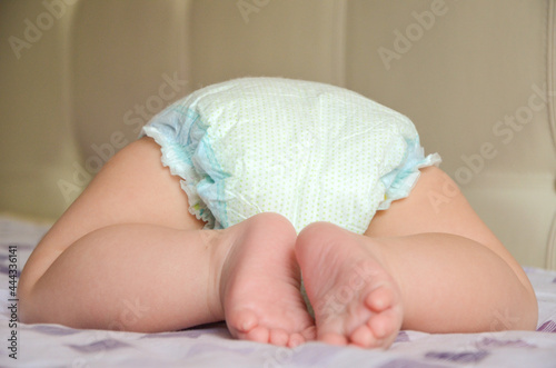 Newborn in a diaper back view. Close-up. Copy space.