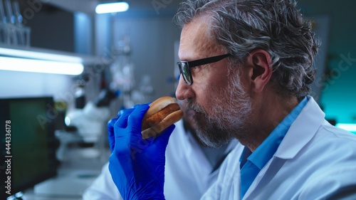 Fotografi Man tasting burger with lab grown meat near colleague