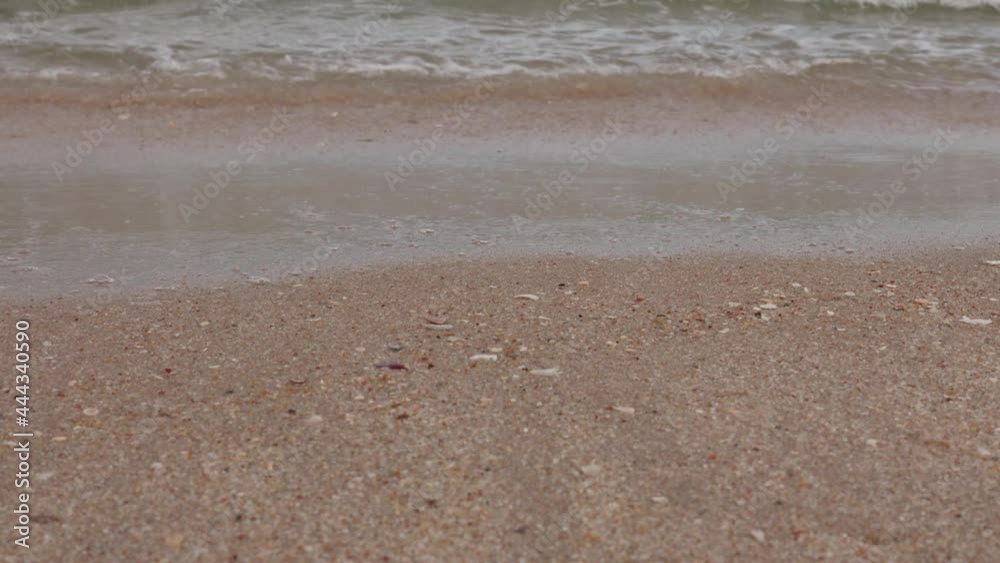 Close up side angle of clean sea waves breaking on sandy beach. Small wave on sand beach for copy space. Sea waves in the daytime. Close up side angle of clean sea waves breaking on sandy beach. Small wave on sand beach for copy space. Sea waves in the daytime.