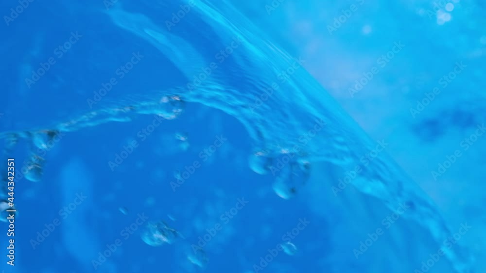 Sparkling overflowing blue transparent water in hot tub or swimming pool. Video banner full HD resolution. Decorative jet or waterfall of water in the pool. Slow motion video Sparkling overflowing blue transparent water in hot tub or swimming pool. Video banner full HD resolution. Decorative jet or waterfall of water in the pool. Slow motion video