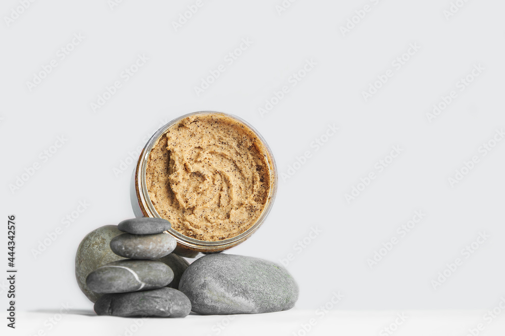 Fototapeta premium Coffee scrub on texture stone and copy space. Сosmetics, skincare products on natural podium. Top view.