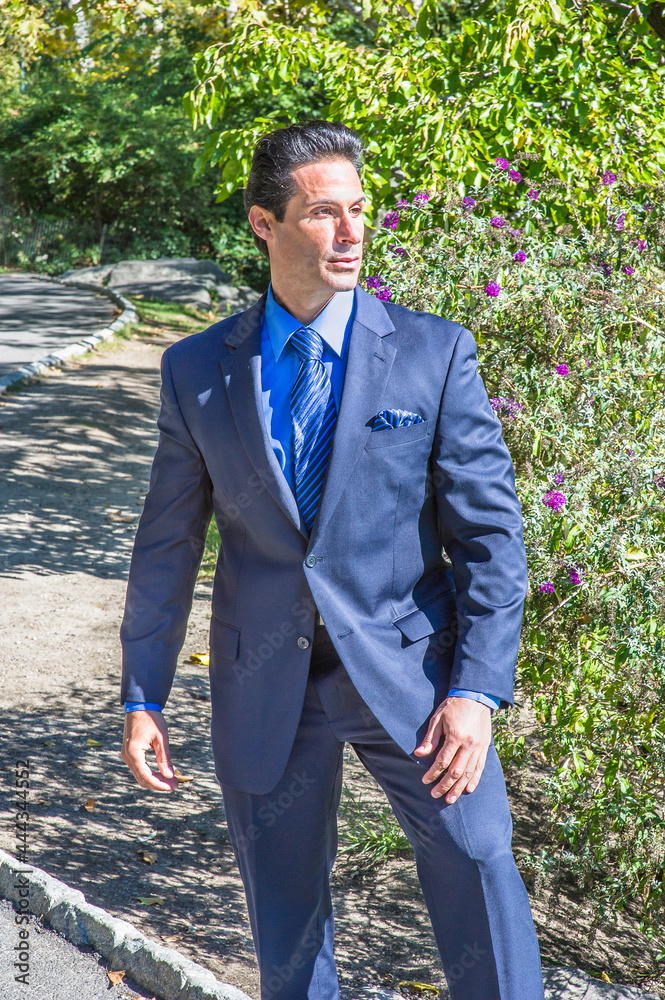 Dressing in a blue suit, blue shirt and blue pattern tie, a strong businessman is standing outside and into deeply thinking. . Dressing in a blue suit, blue shirt and blue pattern tie, a strong businessman is standing outside and into deeply thinking. .