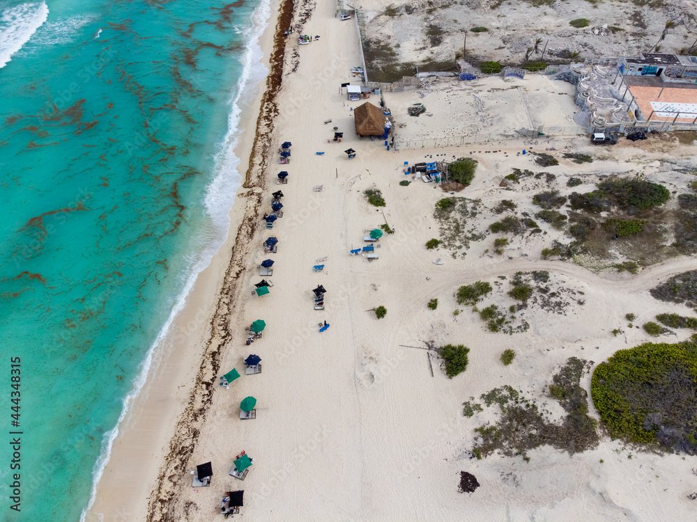 Ocean shore. Environmental pollution. Resort area. There is a lot of garbage lying on the shore. White sand and azure ocean water. Aerial photography. High angle view.