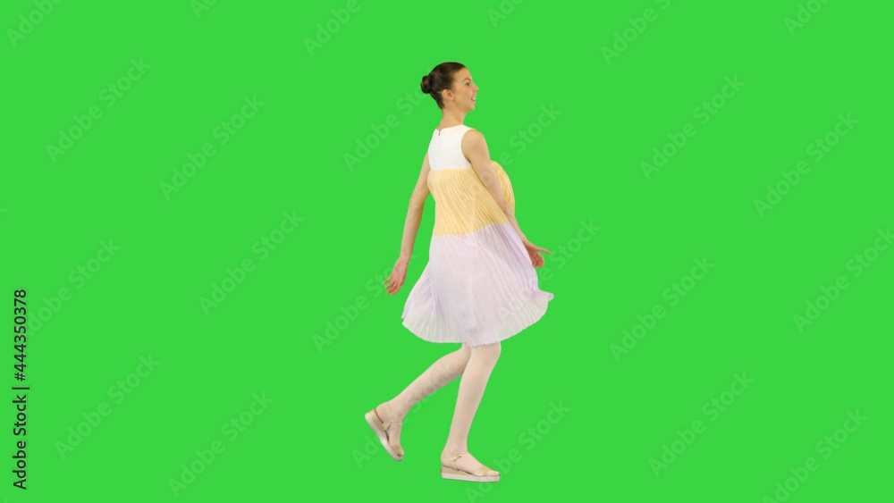 Young beautiful girl in white-yellow dress runs, seemingly happy on a Green Screen, Chroma Key. Young beautiful girl in white-yellow dress runs, seemingly happy on a Green Screen, Chroma Key.