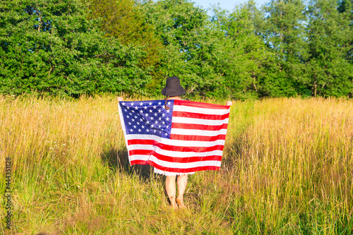 a woman in a field with an American flag. Sunset Walk