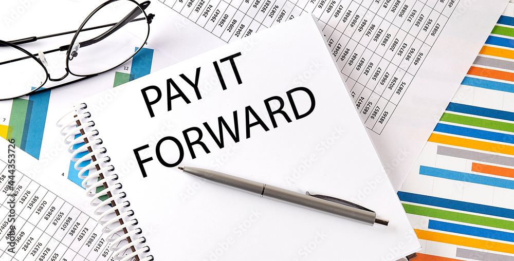 Notebook with text PAY IT FORWARD . Diagram and white background,Business concept Notebook with text PAY IT FORWARD . Diagram and white background,Business concept