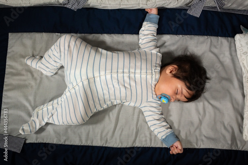 top view of a hispanic baby sleeping in his crib