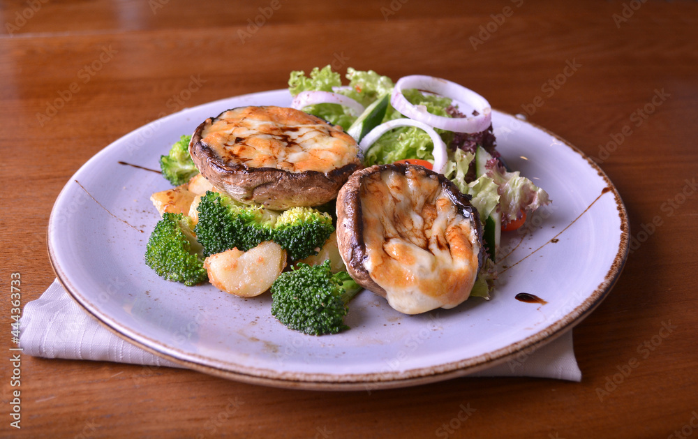 vegetarian grilled big fresh mushroom with bake cheese porbettolo and broccoli vegetables wood table western vegetarian menu