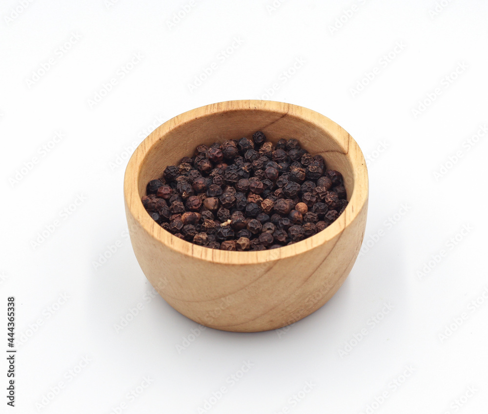 black pepper in a wooden bowl isolated on white background black pepper in a wooden bowl isolated on white background