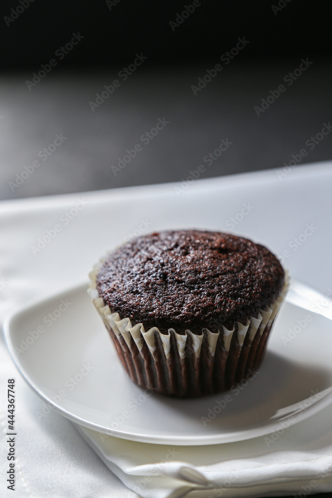 Delicious and fresh chocolate muffins on a gray ceramic table. Delicious and fresh chocolate muffins on a gray ceramic table.