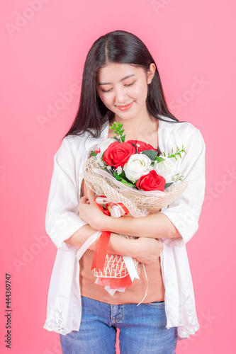 beauty woman Asian cute girl feel happy holding flower red rose and white rose on pink background - lifestyle beautiful woman