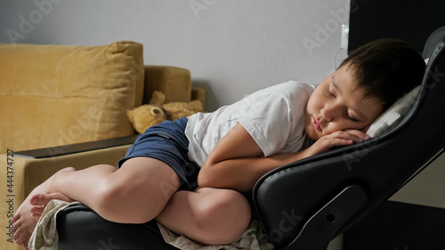 boy sleeping sweetly on a computer chair.