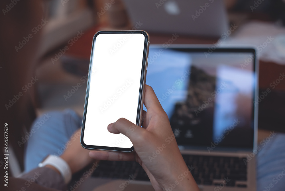 Cell phone mockup image blank white screen. Woman hand holding, using mobile phone in coffee shop, close up Cell phone mockup image blank white screen. Woman hand holding, using mobile phone in coffee shop, close up