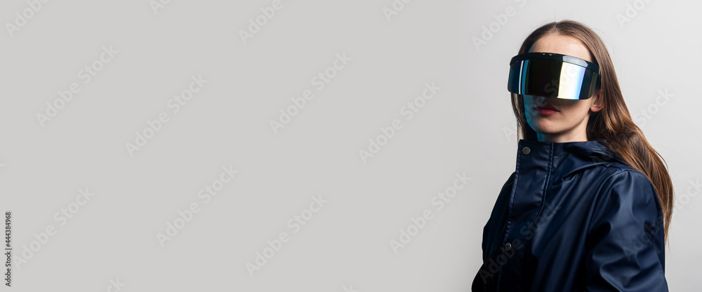 Style woman in VR glasses and in a blue jacket on a light background. Banner Style woman in VR glasses and in a blue jacket on a light background. Banner