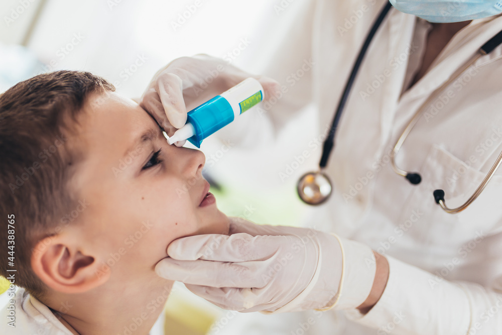 Closeup of doctor pouring eye drops in eye her little patient. Closeup of doctor pouring eye drops in eye her little patient.