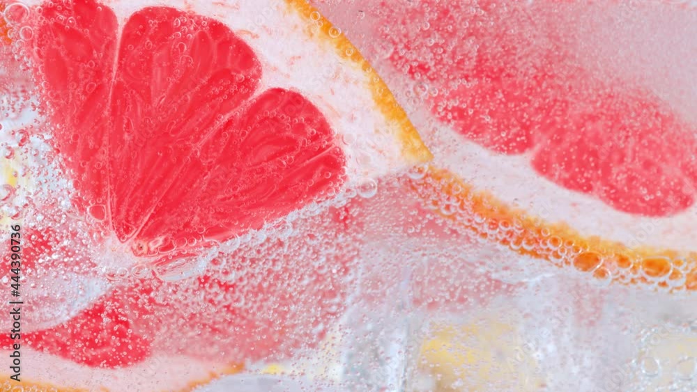 Super Slow Motion Shot of Fizzing Water with Grapefruit Slices and Ice Cubes in Glass at 1000 fps. Super Slow Motion Shot of Fizzing Water with Grapefruit Slices and Ice Cubes in Glass at 1000 fps.