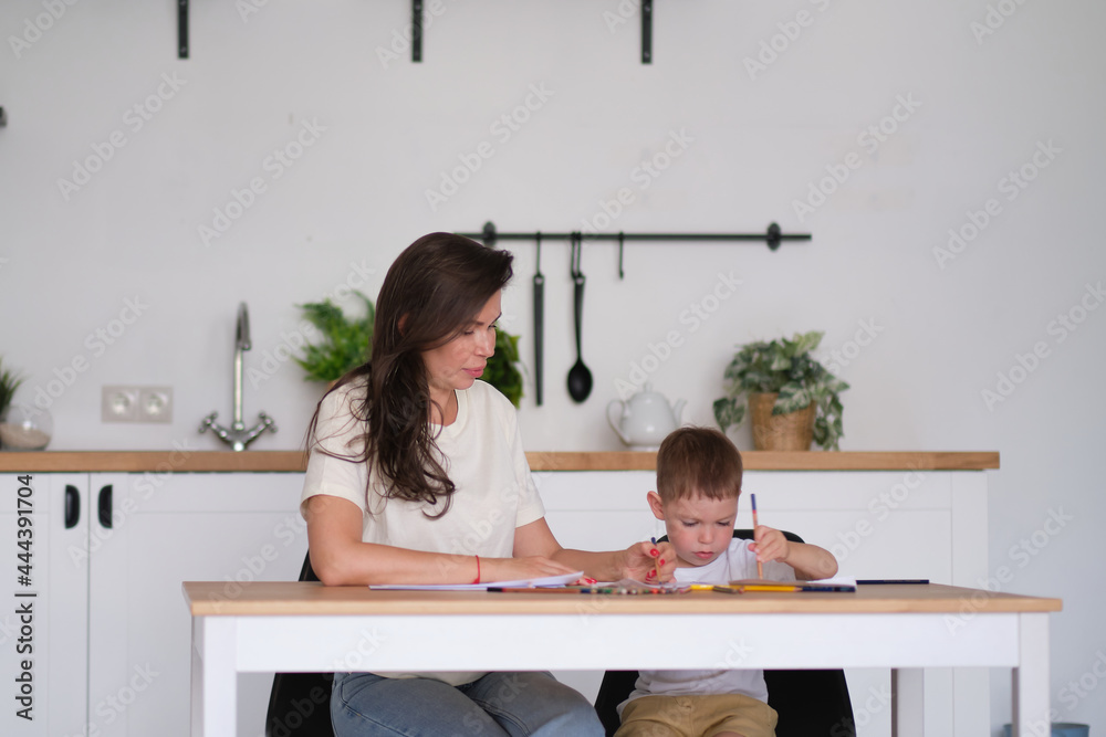 little boy learns to draw. Mom and son have fun drawing with pencils. Children's creativity. little boy learns to draw. Mom and son have fun drawing with pencils. Children's creativity.