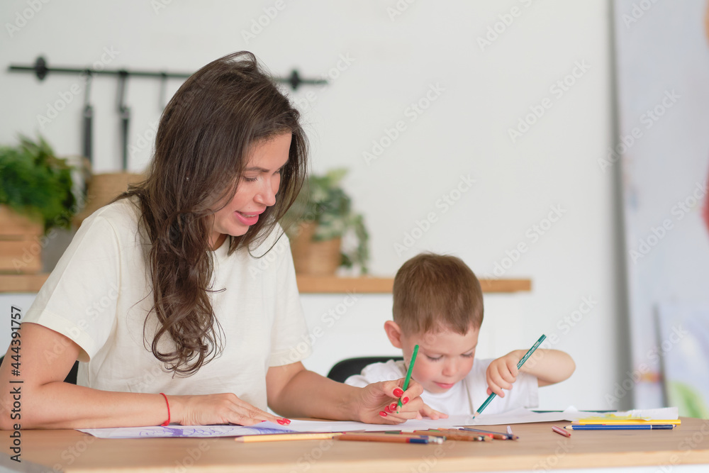 little boy learns to draw. Mom and son have fun drawing with pencils. Children's creativity. little boy learns to draw. Mom and son have fun drawing with pencils. Children's creativity.