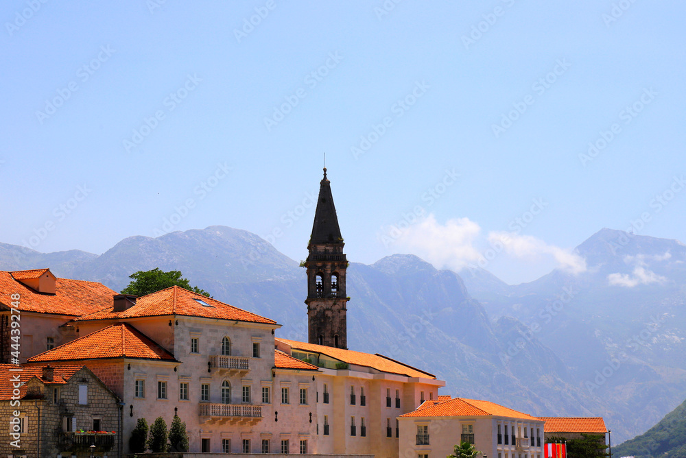 Naklejka premium Old Historic buildings and towers in Perast, Montenegro. A beautiful town in Kotor Bay in summer near high mountains. Adriatic Sea, Montenegro