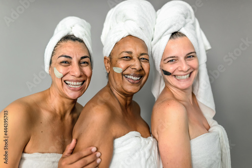 Happy multiracial senior women having skin care spa day - People wellness lifestyle concept