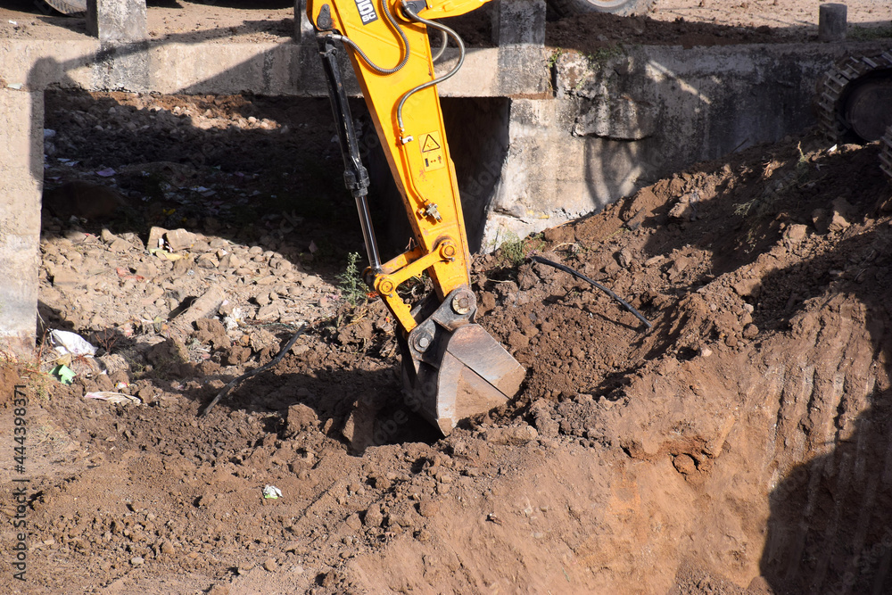 The modern excavator JCB performs excavation work on the construction site The modern excavator JCB performs excavation work on the construction site
