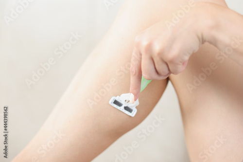 Woman shaving her leg using disposable machine closeup © H_Ko