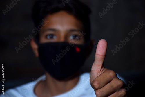 13 years old Asian cute boy wearing protective mask, holding thums up, prevention of Corona virus (Covid -19) and pollution photo