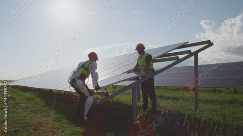 Male engineers installing solar panels together