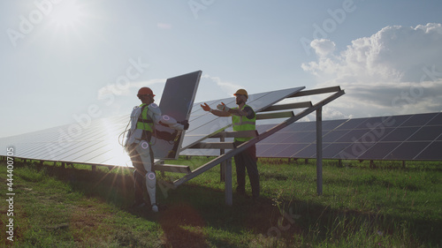 Male engineers installing solar panels together