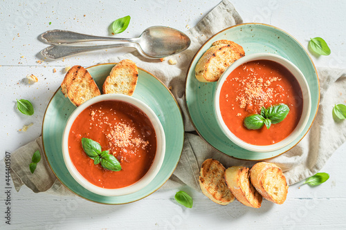 Foto Homemade tomato soup with toasts and basil. Soup with croutons.