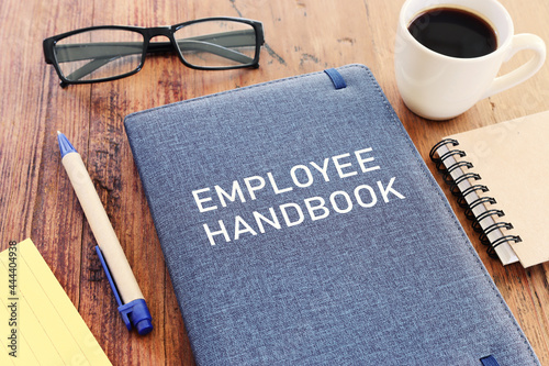Concept image of employee handbook over wooden office table. top view photo