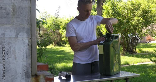 Man is standing and choosing electric charge cable with plug or gas canister selecting fuel type 