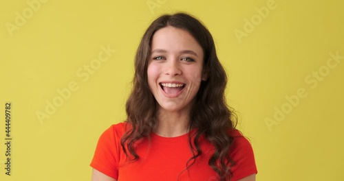 Woman shaking head and saying yes over yellow background