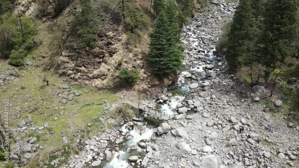 beautiful scenery, true beauty of the nature. aerial drone shot of wooden bridge built upon river flowing through the mountains and rocks, stones. camera moving down keeping bridge in middle. beautiful scenery, true beauty of the nature. aerial drone shot of wooden bridge built upon river flowing through the mountains and rocks, stones. camera moving down keeping bridge in middle.