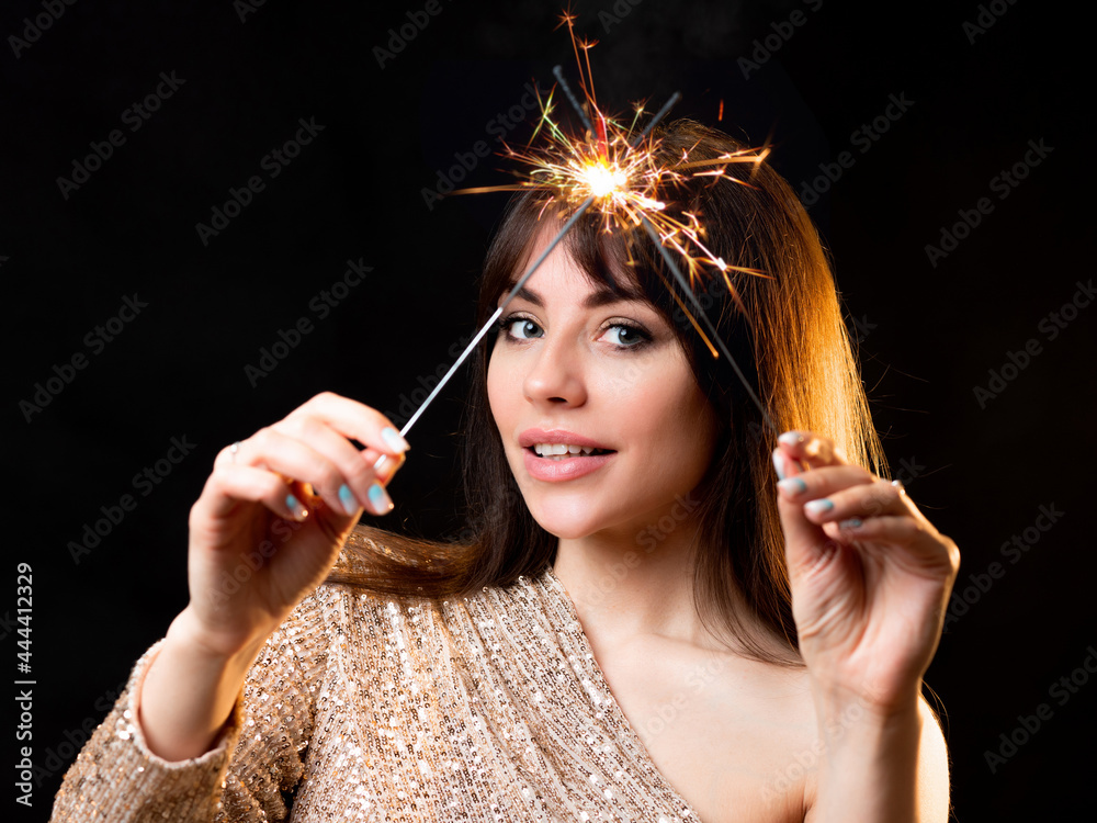 Obraz premium birthday or New Year's eve party. Young beautiful brunette in a gold dress
