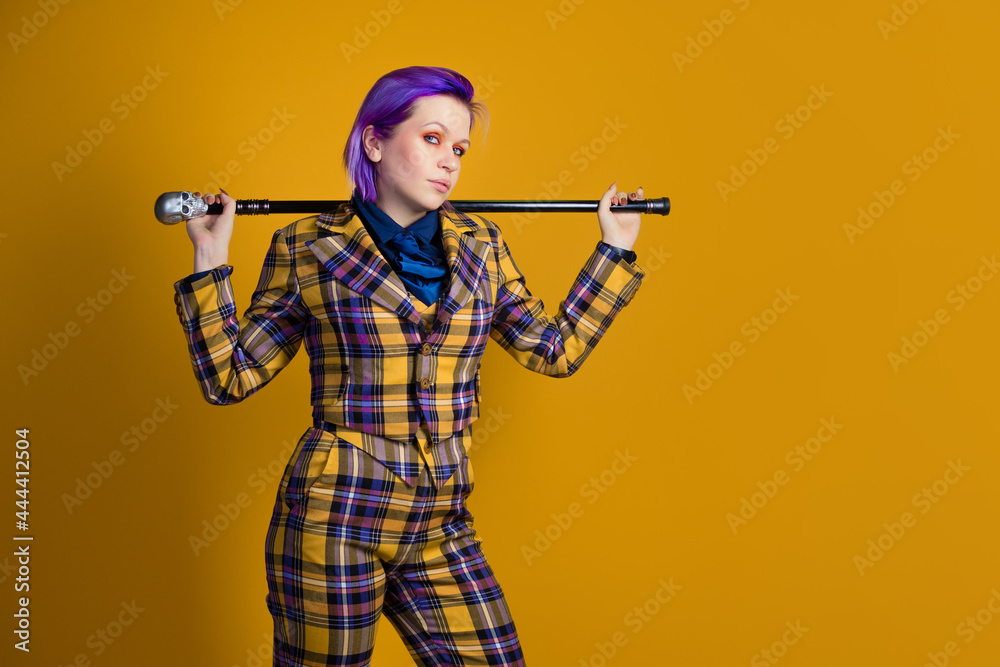 Stylish informal young woman in three-piece suit with decorative walking stick, Stylish informal young woman in three-piece suit with decorative walking stick,